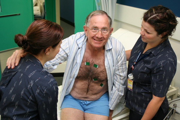 Two nurses helping a patient out of bed