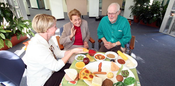 A nurse discussing dietary requirements with two patients